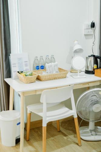 a white table with bottles of water and a fan at Phorpun Resort Lampang in Ban Mai