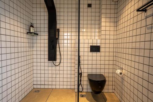 a bathroom with a shower with a toilet in it at Minimalist Panjim in Panaji