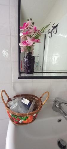 a basket on a sink with flowers in a mirror at 2girasoli piano terra in Pucciarelli