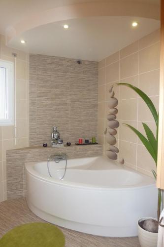 La salle de bains est pourvue d'une grande baignoire blanche. dans l'établissement Villa with terrace and garden, à La Méaugon