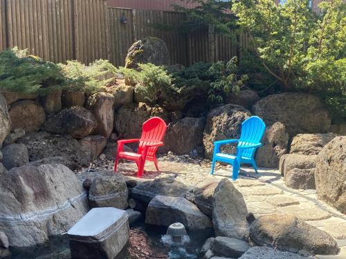 three chairs sitting next to a pond in a garden at Moritsubetsu in Tsubetsu