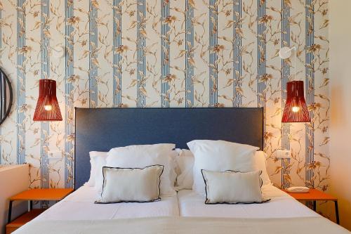 a bedroom with a white bed with two lamps at Hotel Ribadesella Playa in Ribadesella