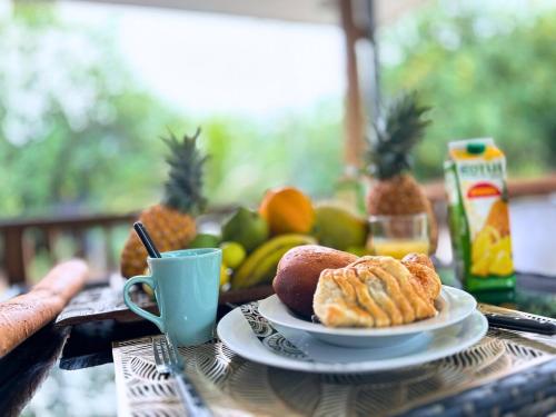 a table with a plate of pastries and a cup of coffee at Fare Rau - Beau Bungalow Moorea in Moorea