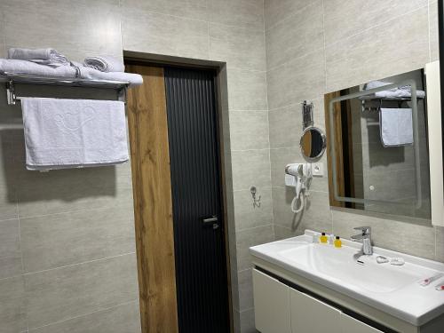 a bathroom with a sink and a mirror at Safia Guest House in Andijan