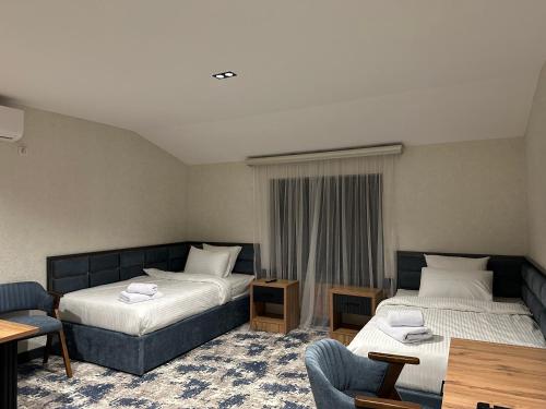 a hotel room with two beds and a table at Safia Guest House in Andijan