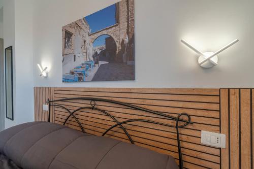 ein Schlafzimmer mit einem Bett und einem Bild an der Wand in der Unterkunft Bove Marino Apartments Marzamemi in Reitani