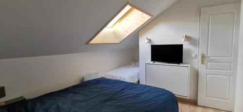 una camera da letto con un letto e una TV a schermo piatto di Le Crey du Quart a Valmeinier