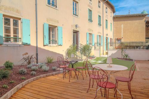 a patio with tables and chairs on a wooden deck at Wellin'Ars in Ars-sur-Formans