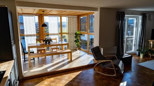 a living room with a table and chairs and a room with windows at Apartment Nanni in Kirchanschöring