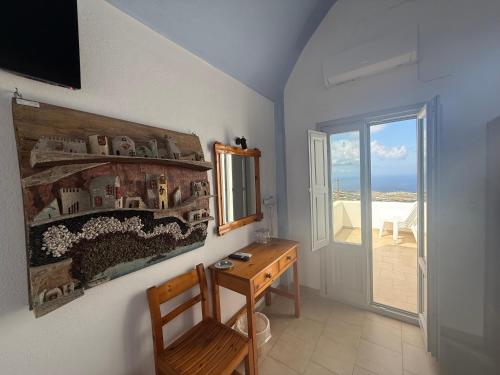 a room with a desk and a painting on the wall at Hotel Hellas in Fira