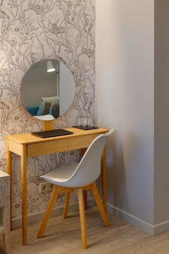 a desk with a white chair and a mirror at Hotel Ribadesella Playa in Ribadesella
