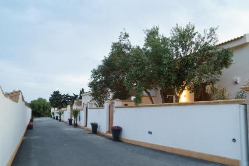 a white fence on a street with houses at Bono Vacanze Villa San Marco Luxury Holidays Homes in Sciacca