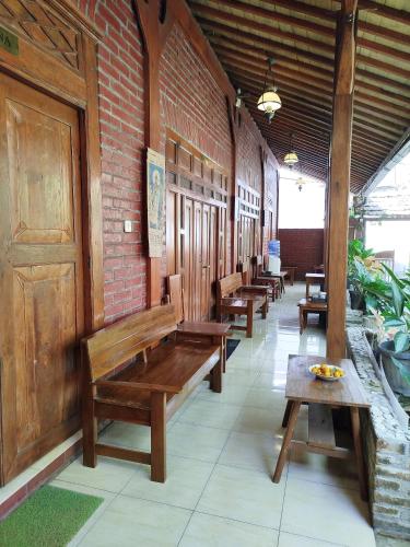 a row of wooden benches in a building at Dapur Ethnic Homestay in Bantul