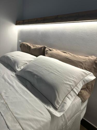a bed with white sheets and pillows on it at Dimora 21 in Ruffano