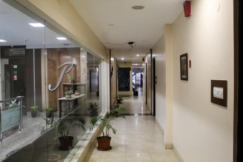 a hallway with potted plants in a building at Hotel Rajawas in Dibrugarh