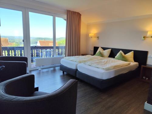 a hotel room with a bed and a balcony at Garni Hotel & Ferienwohnungen Seeschlößchen in Waldeck