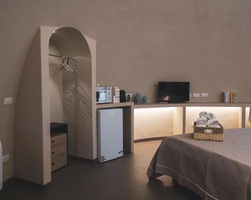 a room with a bed and a small refrigerator at Nausicaa Guesthouse in Marsala