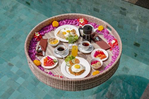 een bovenaanzicht van een ontbijttafel met eten en drinken bij Puri Sedana Ubud Villa in Ubud