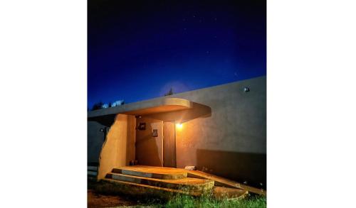 a house with a light on the side of it at night at 宮古島の自然豊かで静かなエリアroom1オリジナルインテリア小物が溢れる空間 in Miyako Island