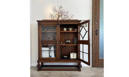 a wooden cabinet with glass doors and a shelf at 宮古島の自然豊かで静かなエリアroom1オリジナルインテリア小物が溢れる空間 in Miyako Island