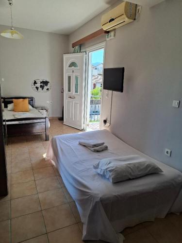 a bedroom with a bed and a window and a door at Belleza Villa in Lixouri