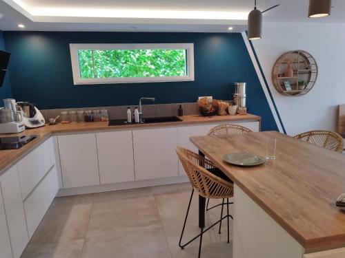 une cuisine avec une table en bois et une fenêtre dans l'établissement Maison de vacances familiale au calme entre terre et mer, à Le Minihic-sur-Rance