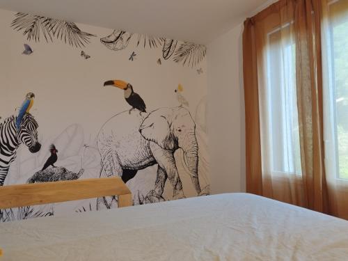 une chambre avec une fresque d'éléphants et d'oiseaux sur le mur dans l'établissement Maison de vacances familiale au calme entre terre et mer, à Le Minihic-sur-Rance