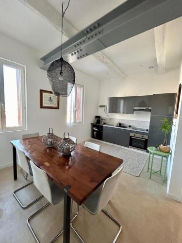 a dining room with a wooden table and chairs at Elegance Centre Sète in Sète