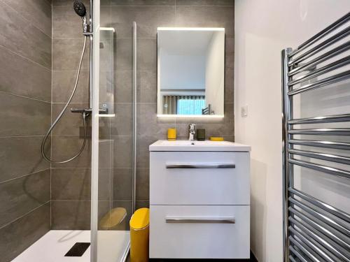 une salle de bain avec un lavabo blanc et une douche dans l'établissement La Croisette, YourHostHelper, à Sainte-Maxime