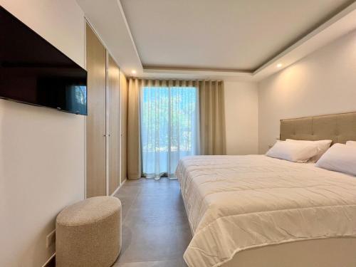 une chambre avec un grand lit et une fenêtre dans l'établissement La Croisette, YourHostHelper, à Sainte-Maxime