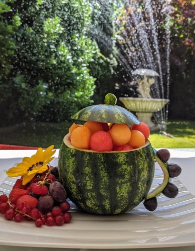 a bowl of fruit sitting on a table next to a fountain at GORITSCHNIGGs Hotel - Self Check-In in Velden am Wörthersee