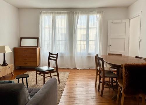 un salon avec une table et des chaises dans l'établissement Appartement spacieux de 3 chambres pour 6 personnes, à Clermont-Ferrand