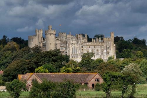 a castle on top of a hill with a building at Angel Cottage in stunning Arundel in Arundel