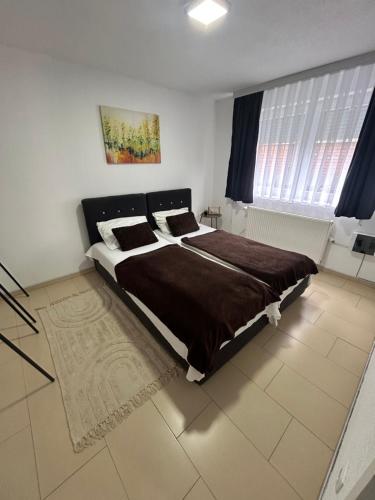 a bedroom with a large bed and a window at Apartmani Star in Tuzla