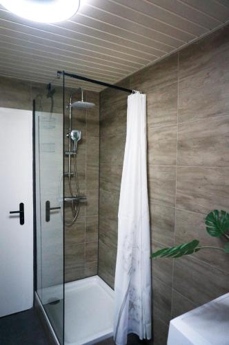 a shower with a shower curtain in a bathroom at BERG & WALD Ferienwohnungen in Schönau am Königssee