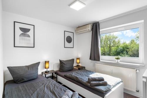 two beds in a bedroom with a window at BE01 Große Wohnung in Dieburg in Dieburg