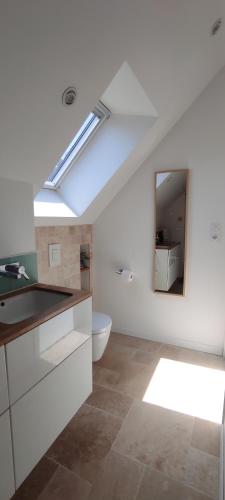 une salle de bain blanche avec un lavabo et un miroir dans l'établissement Maison de vacances familiale au calme entre terre et mer, à Le Minihic-sur-Rance