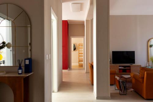 a hallway leading to a living room with orange furniture at Henry's House in Parma