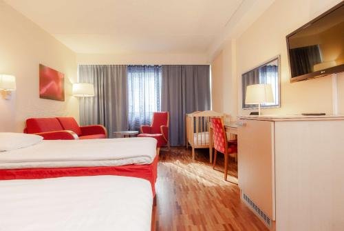 a hotel room with two beds and a living room at Scandic Mikkeli in Mikkeli