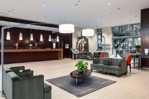 a lobby with couches and chairs and a waiting room at NH Den Haag in The Hague