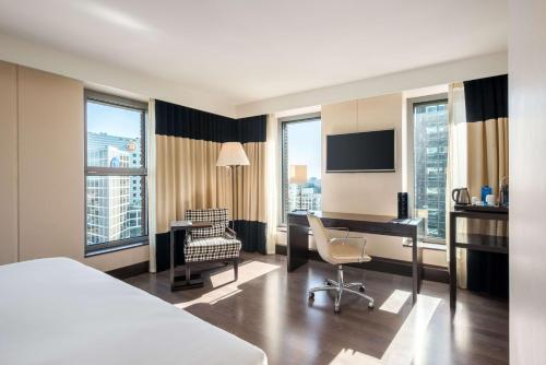 a hotel room with a bed and a desk and a chair at NH Den Haag in The Hague