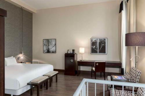 a hotel room with a bed and a desk at NH Den Haag in The Hague