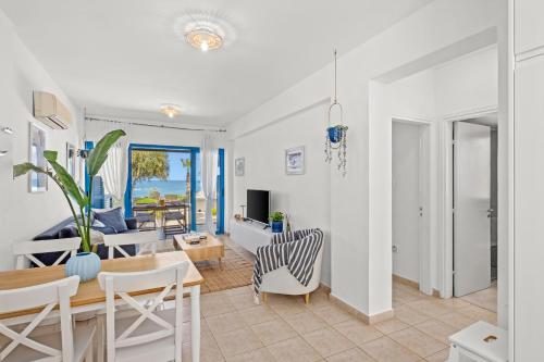 a dining room and living room with a table and chairs at Aura Beachfront Residence by Nomads in Polis Chrysochous