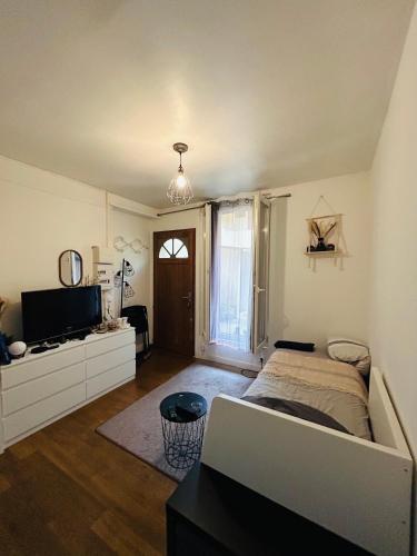 une chambre avec un lit et une télévision dans l'établissement Studio entre Issy et Pte de Versailles, à Issy-les-Moulineaux