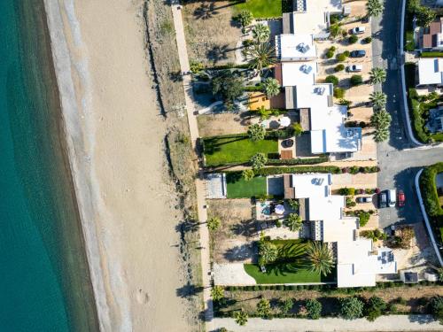 an aerial view of a beach with houses and the ocean at Aura Beachfront Residence by Nomads in Polis Chrysochous