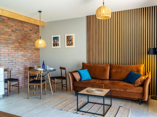 a living room with a couch and a table at Pod Lasem Apartamenty in Łukęcin