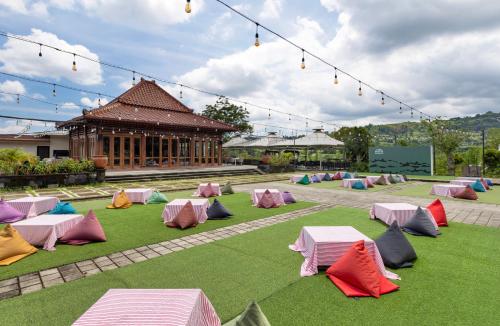 een groep tenten op het gras voor een gebouw bij The Glamping at ARTOTEL Pelangi Park in Pasirkuda