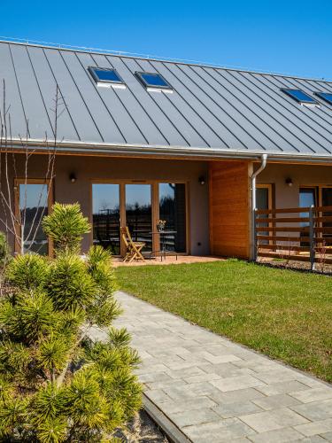a house with a metal roof on top of it at Pod Lasem Apartamenty in Łukęcin