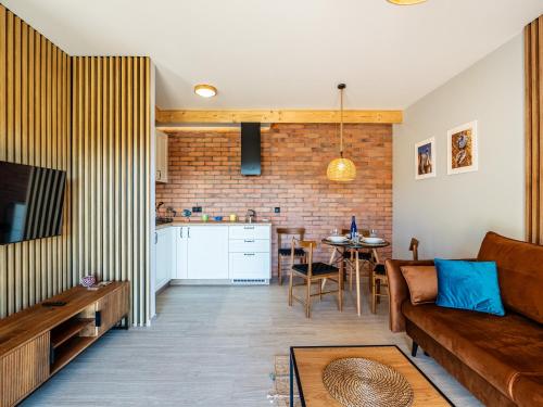 a living room with a couch and a kitchen at Pod Lasem Apartamenty in Łukęcin