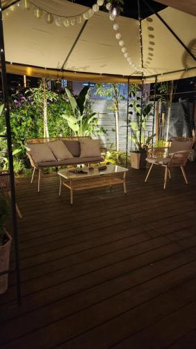 a wooden deck with a bench under an umbrella at בוס-תן בגולן in Giv'at Yo'av